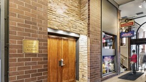 A brick building entrance with a wooden door labeled "Grand Galleria Condominiums." - One BDR In Heart of Park City! (Park City)
