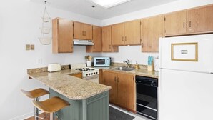 A modern kitchen with wooden cabinets, a granite countertop, a built-in stove, a microwave, a sink, and a refrigerator. - One BDR In Heart of Park City! (Park City)