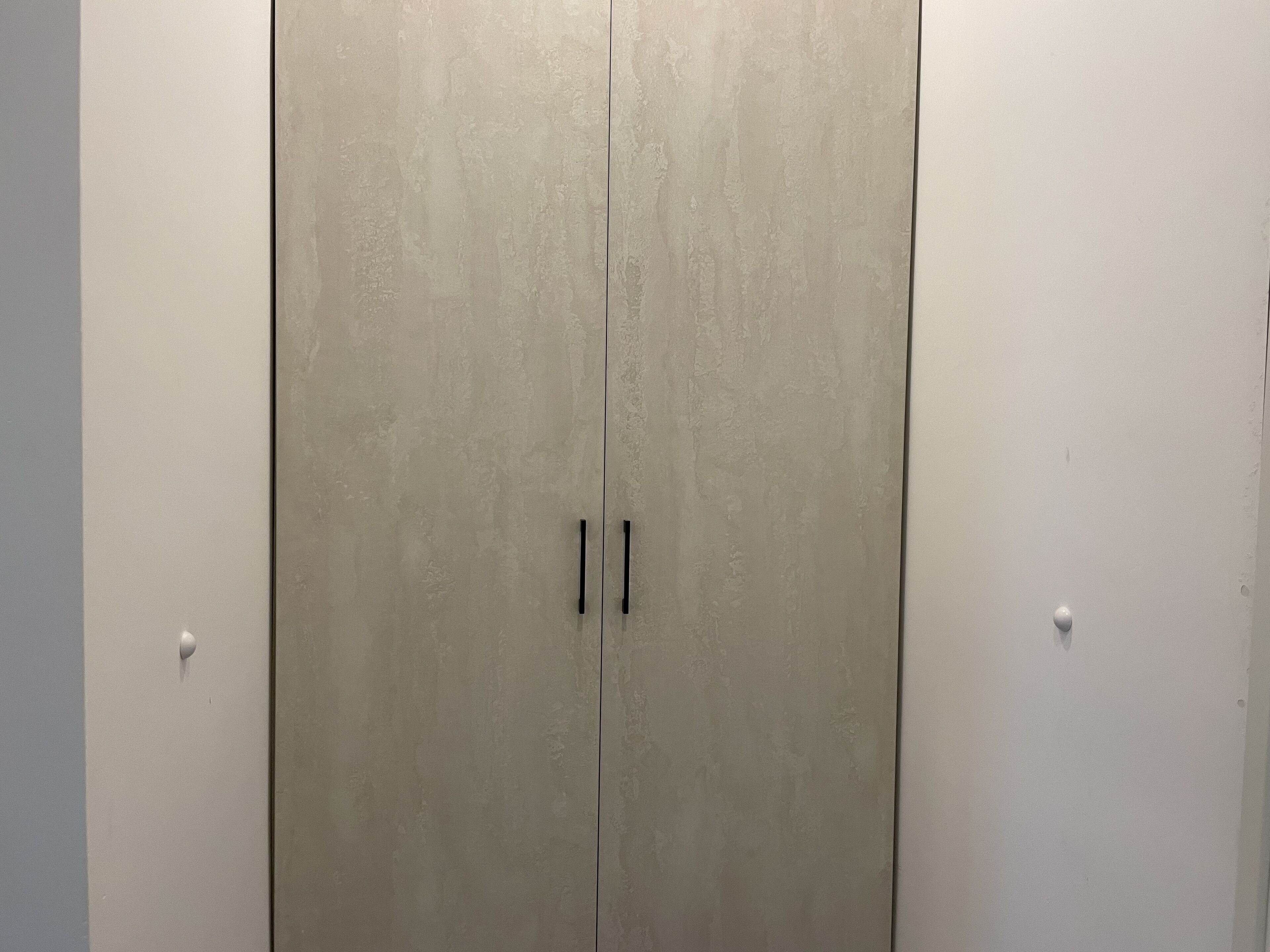A closed wardrobe with two handles.