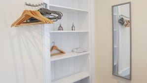 A white wardrobe with multiple shelves, a hanging rack, and a mirror. - Jacobite house (Inverness)
