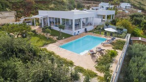 A modern villa with a swimming pool, surrounded by lush greenery and a stone retaining wall. - Villa Mayas - Scopello with private pool (Castellammare del Golfo)