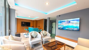 A modern living room with a flat-screen TV, two sofas, a coffee table, and a large window. - Funplace Beach (Himmafushi)