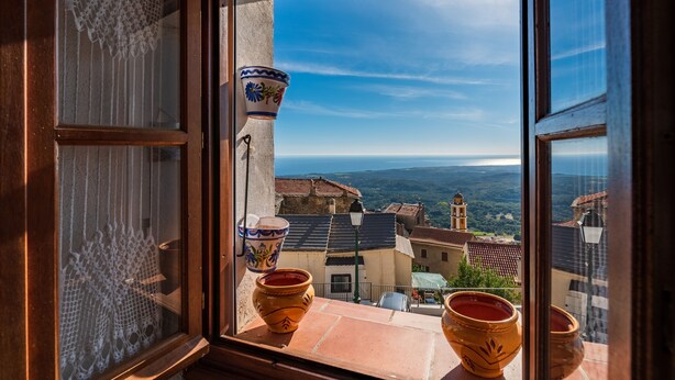 A window with a view of a town, including buildings and a clear sky. - Pentone - One Bedroom Apartment, Sleeps 4 (Cervione)