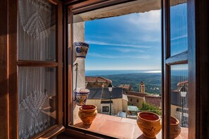 A window with a view of a town, including buildings and a clear sky.