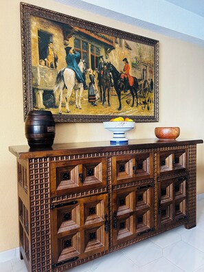 Un buffet en bois orné de sculptures complexes, avec un tableau accroché au-dessus.