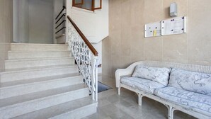A staircase with white steps and a wooden handrail, leading to a room with a white sofa and a bulletin board on the wall. - Altea Beach Front 'Oden 5' < 4 persons (Altea)