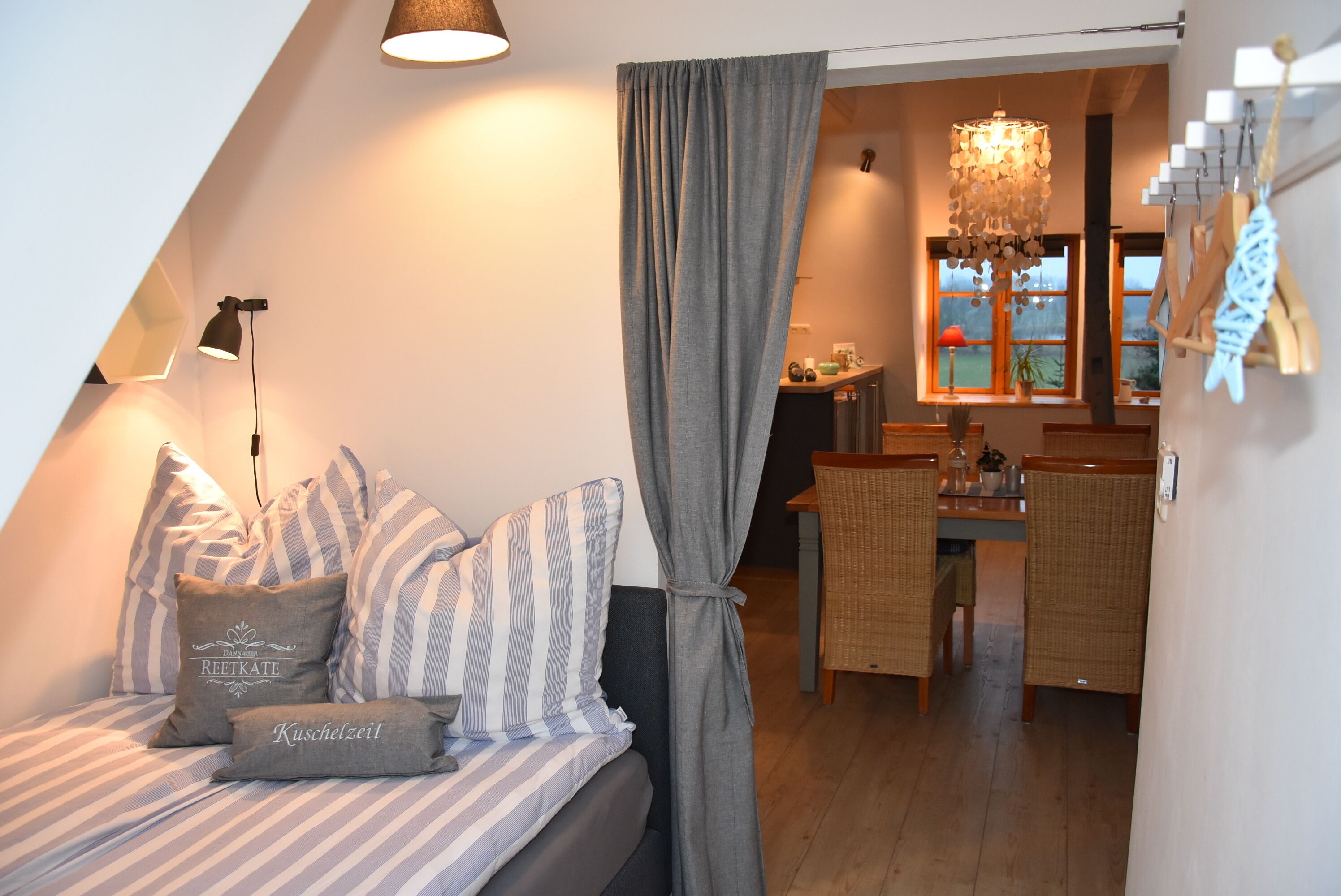 A cozy room with a bed, a dining area, and a view of the outdoors.