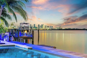 A waterfront pool with a city skyline in the background.