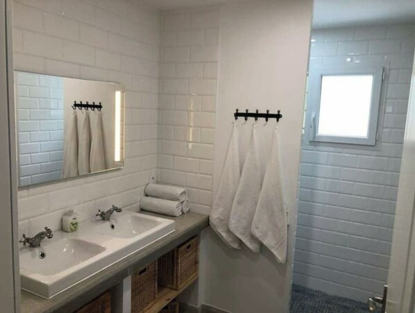 A bathroom with two sinks, a mirror, and a towel rack.