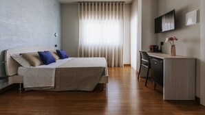 A bedroom with a bed, a desk, and a TV. - apuliablue (Bari)