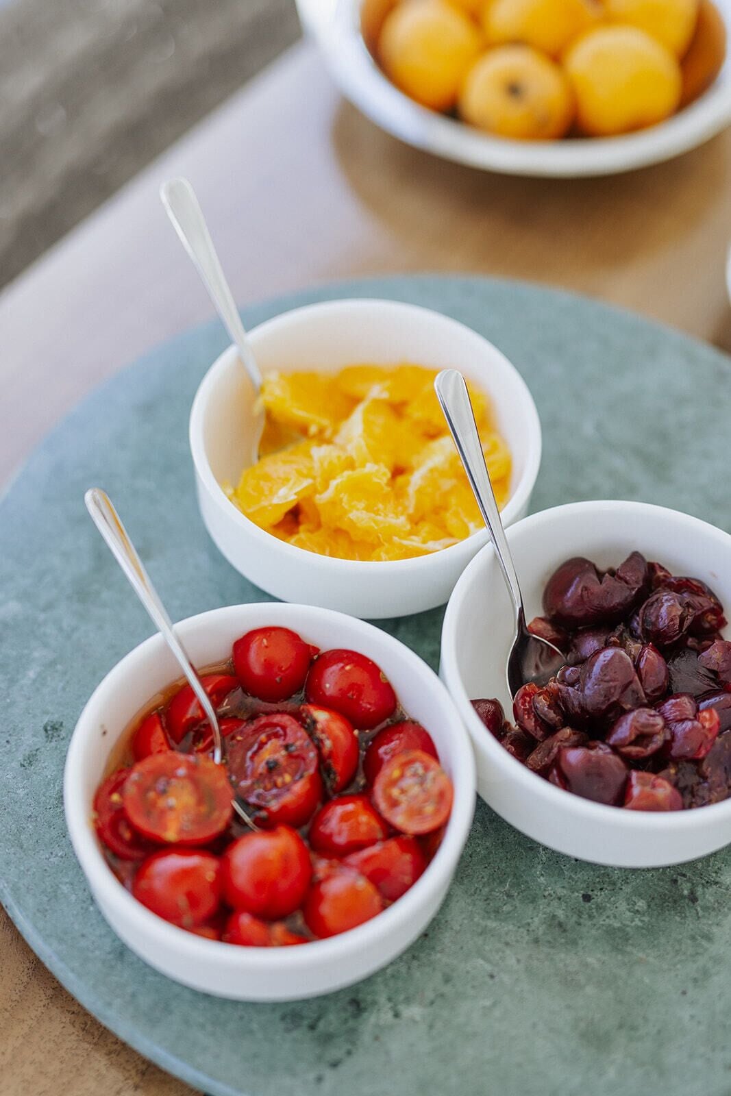Three bowls of food on a round table.