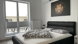 Quarto com cama, radiador, janela e ventoinha no teto.