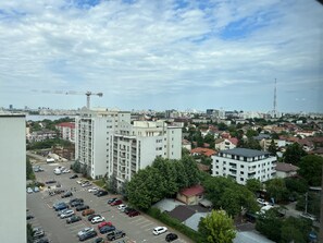 A high-rise building with multiple floors, surrounded by a parking lot and smaller residential buildings. - 4 Room Penthouse Terrace W18-W19 (Bucharest)