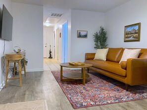 Relax in this stylish living room with a leather sofa, coffee table, and patterned rug.