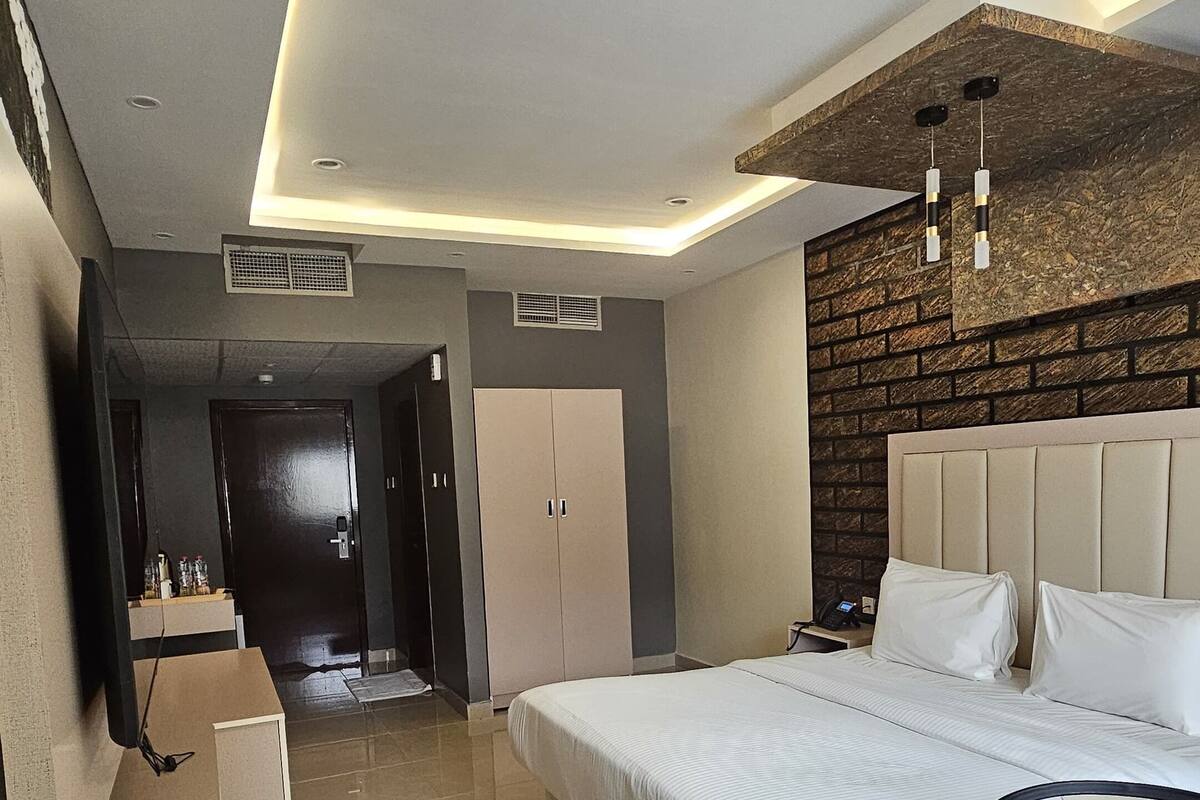 Una habitación de hotel moderna con una cama grande, un escritorio y una zona de comedor.