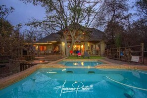 A pool area with a house in the background. - Villa - Sleeps 10 - Pool - Patio - Housekeeping (Nkomazi)