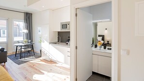 A modern apartment with a kitchen, dining area, and a visible bedroom. - 150 Rivoli Apartments - 3ºA by LovelyStay (Porto)