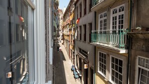 A narrow street with buildings on either side, featuring balconies and windows. - Riverside Cozy Studio by LovelyStay (Porto)
