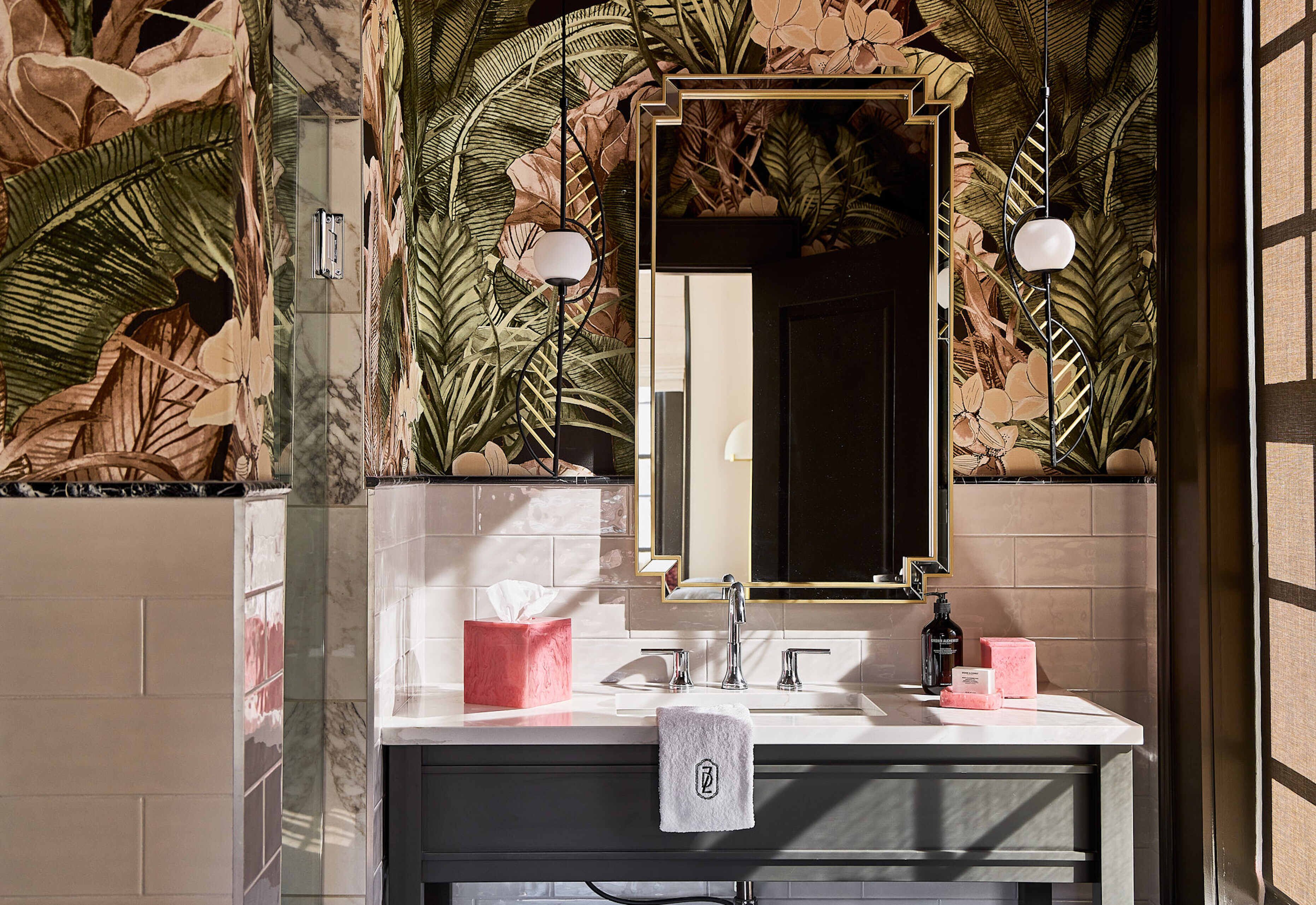 A bathroom with a marble sink, a mirror, and a towel hanging on the wall.