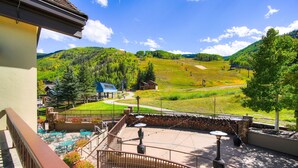 A terrace with outdoor seating, a view of a mountainous landscape, and a ski lift in the background. - Golden Peak Luxury 4 BR Penthouse - Ski-in/out by RedAwning (Vail)