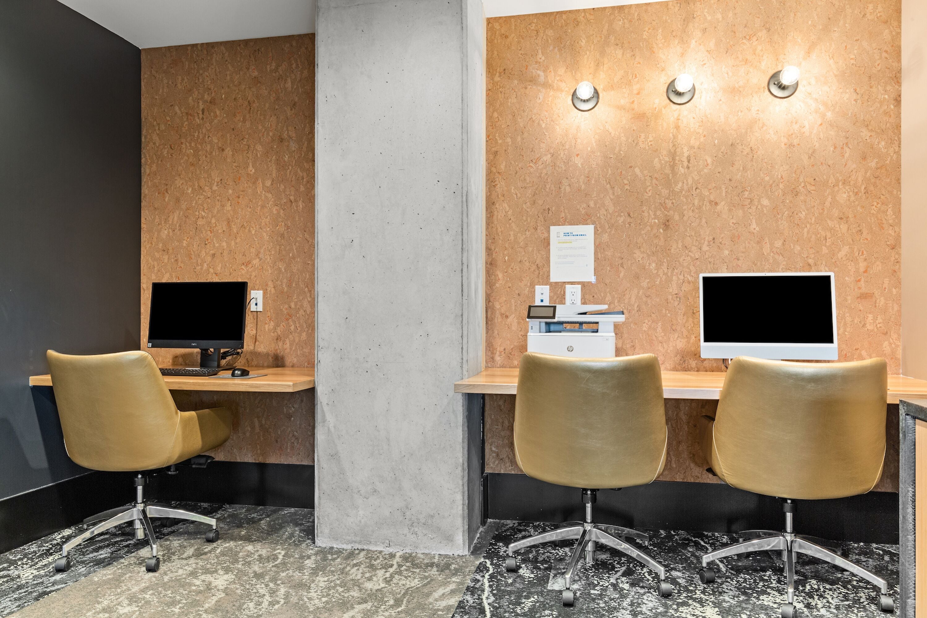 A reception area with two desks, each with a computer monitor, a printer, and a chair.