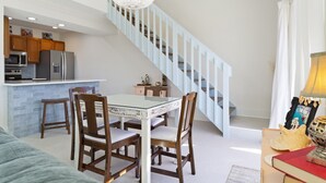 A modern kitchen with a central island, wooden chairs, and a chandelier. - Sea Cabins 2B - Newly Renovated, Heated Community Pool, Deeded Beach Access! (Miramar Beach)