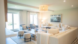 Una sala de estar moderna con sofá, sillones y una mesa de centro.
