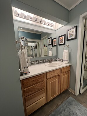 Een bad/douchecombinatie, een haardroger, handdoeken, zeep