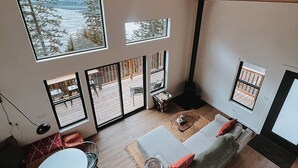 Un vaste espace de vie doté d’un haut plafond, de grandes fenêtres et d’un coin salon confortable.