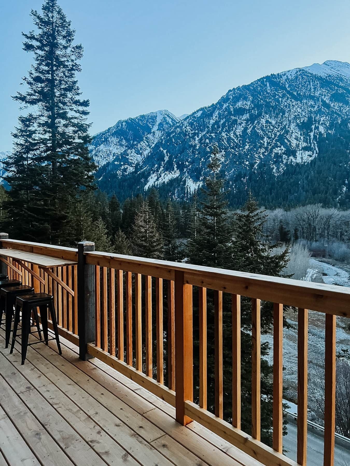 A wooden deck with a view of snow-covered mountains.