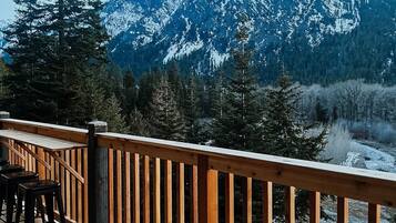 A wooden deck with a view of snow-covered mountains.
