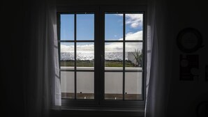 A window with a view of the ocean and a grassy area. - Estrela do Atlântico (Açores)