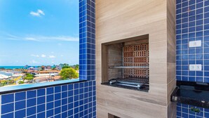 A kitchen with blue tiles, a brick oven, and a view of the sea. - Porto Blue ao mar de Porto G - Carpediem (Ipojuca)