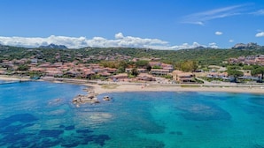 A coastal town with clear blue waters, sandy beaches, and red-roofed buildings. - Blu Hotel Laconia (Arzachena)