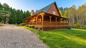 A log cabin with a porch, a chimney, and a gravel driveway. - *Timber & Tin* Family Retreat~Creek~Arcade~Hot Tub (Suches)