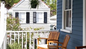Une véranda avec deux fauteuils à bascule et une plante en pot.