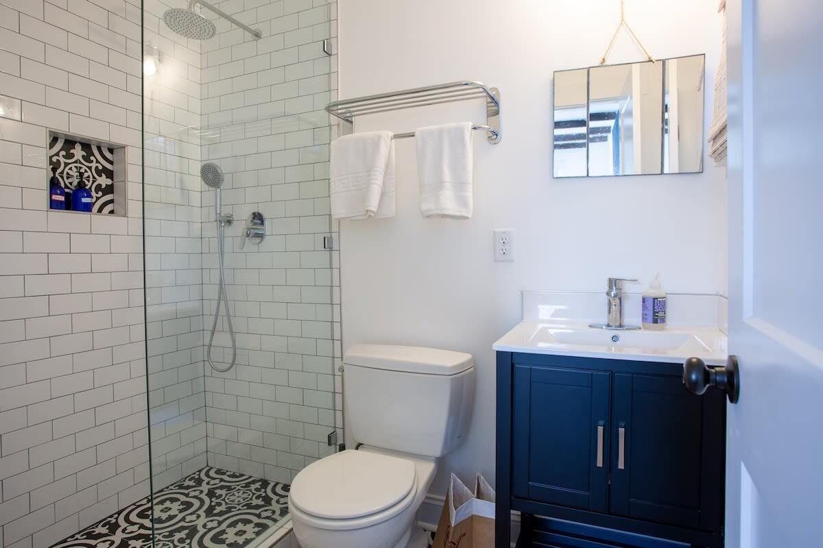 A bathroom with a shower, toilet, and sink.