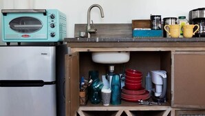 Una cucina con un tostapane vintage, un lavello e diversi utensili e stoviglie.