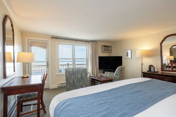 Une chambre d’hôtel équipée d’un lit, d’un bureau, d’une chaise, d’une télévision et d’une fenêtre donnant sur un paysage agréable.