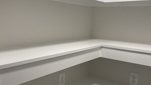 A corner of a room with white walls and built-in shelves. There are two electrical outlets visible on the shelves. - Centrally Located - Newly Built - Walk To The Beach! (Avon)