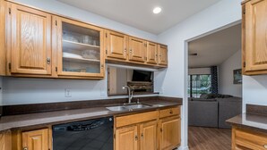 A kitchen with wooden cabinets, a dishwasher, and a built-in oven.