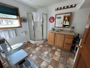 A bathroom with a shower, toilet, sink, and vanity. - 'Northside' Cottage w screened in porch (Cedarville)