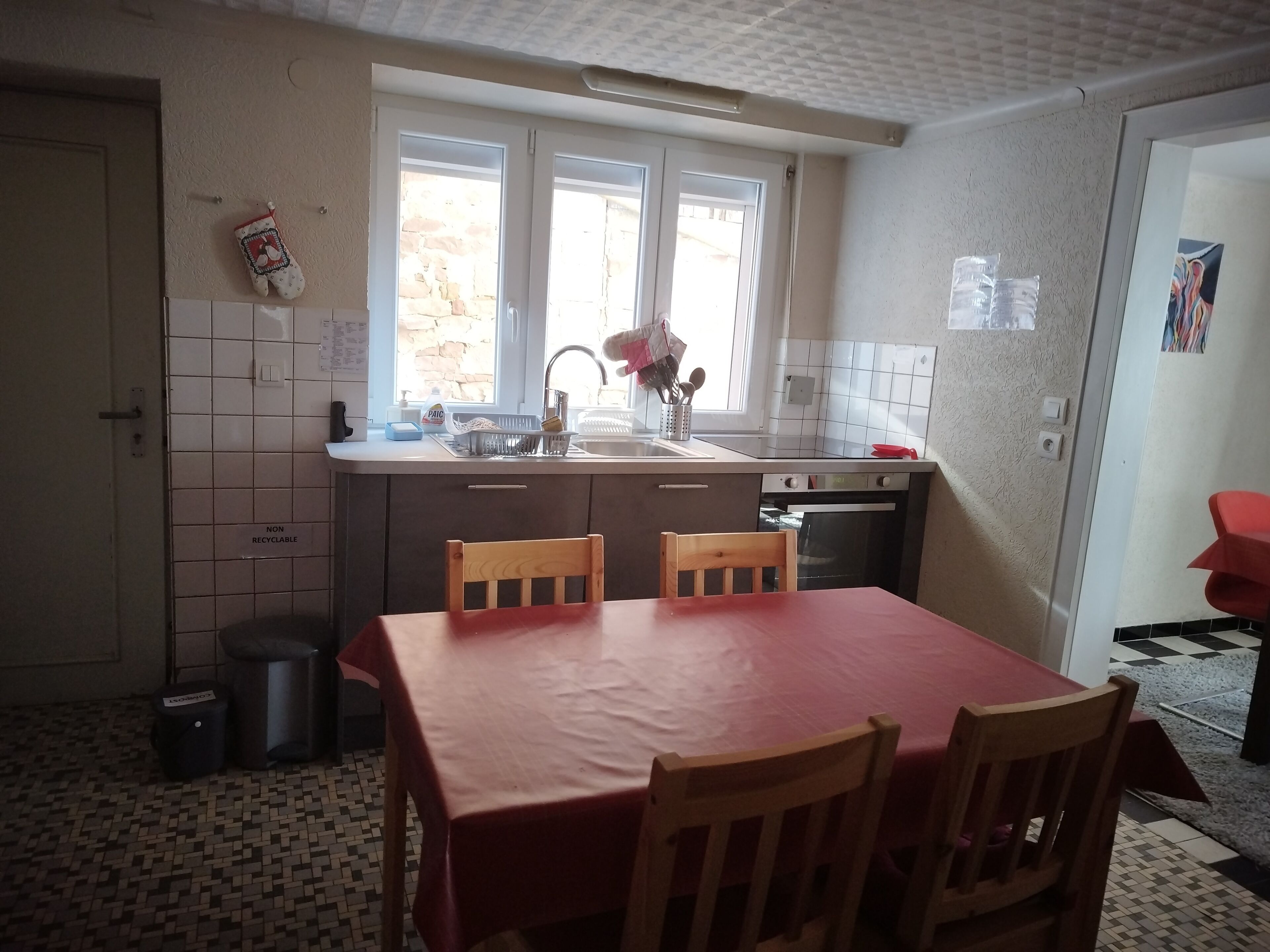 A compact kitchen with a dining table, chairs, a sink, and a stove.