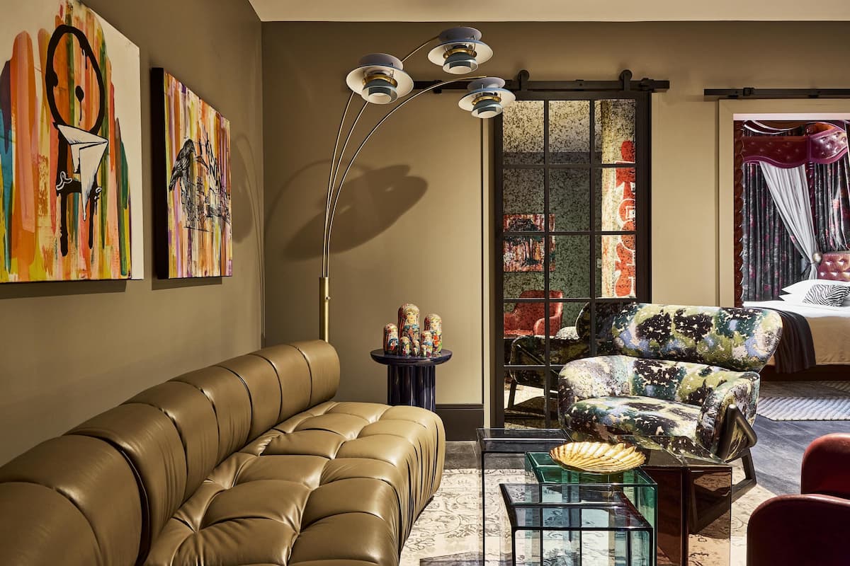 A modern living room with a leather sofa, a patterned armchair, and a floor lamp.