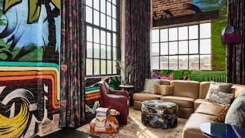 A modern living room with a large window, a sofa, a coffee table, and a decorative horse statue.