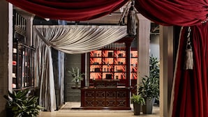 Une pièce avec un autel en bois, des rideaux rouges et un mur orné de motifs.