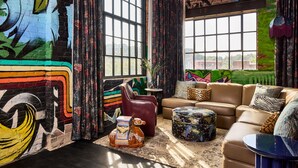 Un salon moderne avec une grande fenêtre, un canapé, une table basse et une statue équestre décorative.