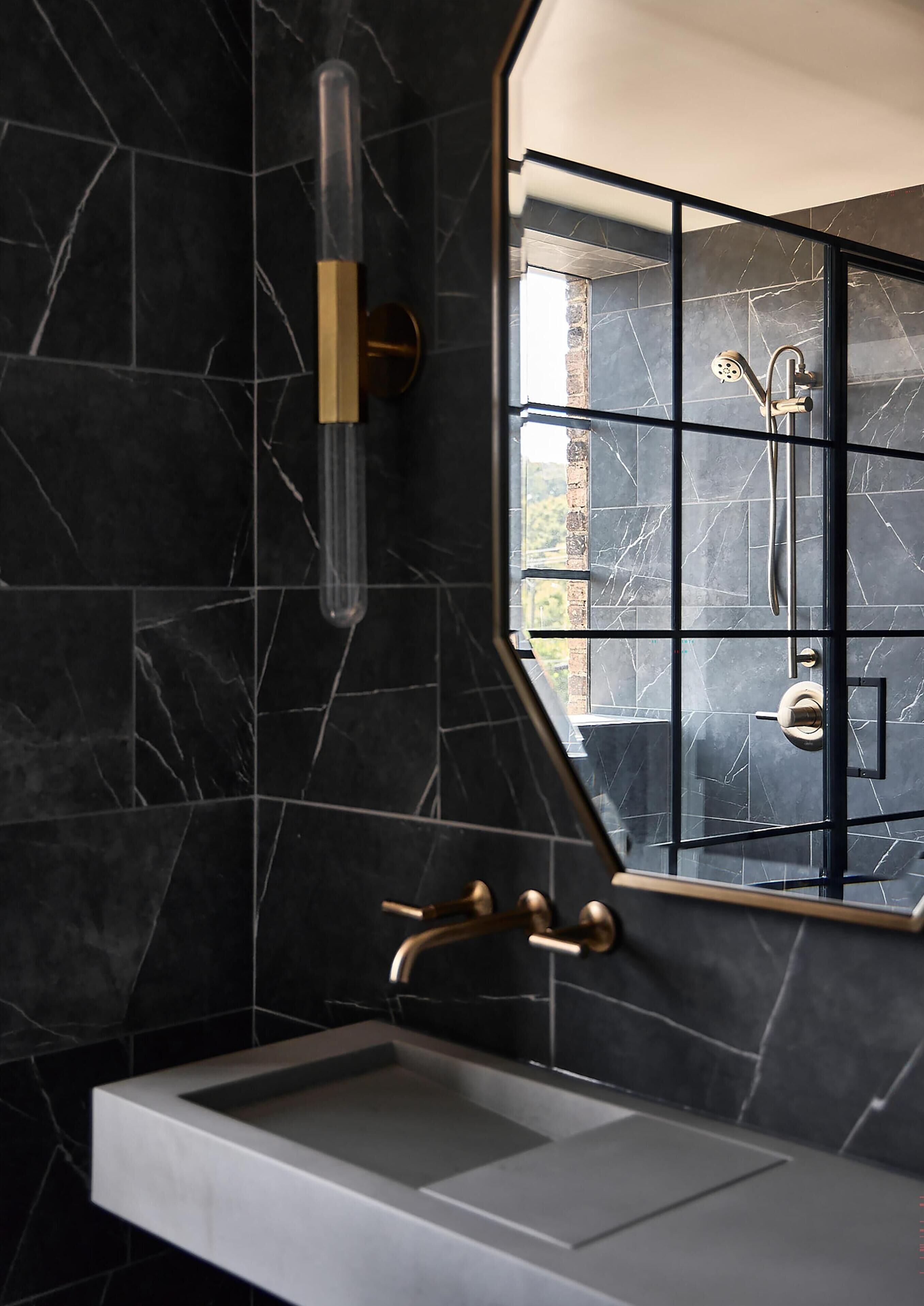 Un baño con diseño moderno, que incluye un espejo grande, ducha integrada y lavamanos minimalista.