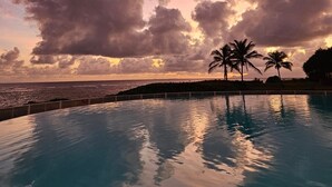 A pool with a view of the ocean and palm trees under a cloudy sky. - Guadeloupe, Saint-François Anse des Rochers, 1/4 villa , vue mer citerne wifi pr (Saint-François)