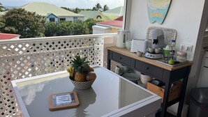 A balcony with a table, a bowl of fruit, and a coffee maker. - Guadeloupe, Saint-François Anse des Rochers, 1/4 villa , vue mer citerne wifi pr (Saint-François)
